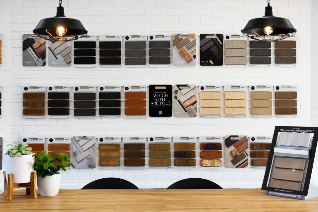 PGH Selection Centre with samples and product info on the wall and customers at a table with a service agent.